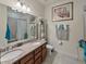 Bright bathroom featuring a double vanity with granite countertop and tiled shower with glass door at 10404 Scarlet Chase Dr, Riverview, FL 33569