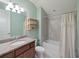 Bright bathroom with a decorative mirror, vanity, tub and shower combo with tile surround at 10404 Scarlet Chase Dr, Riverview, FL 33569
