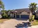 Charming single-story home featuring a two-car garage, paved driveway, and mature landscaping at 10404 Scarlet Chase Dr, Riverview, FL 33569