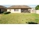 Home's exterior view features a screened patio and a spacious, well-maintained lawn at 10404 Scarlet Chase Dr, Riverview, FL 33569