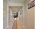 Inviting hallway with neutral tones, tiled floors, and staircase view to the living area at 10404 Scarlet Chase Dr, Riverview, FL 33569