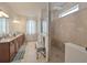 Spacious bathroom with double vanity, granite countertops, a separate toilet room, and a tile walk-in shower at 10404 Scarlet Chase Dr, Riverview, FL 33569