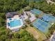 Aerial view of community pool and tennis courts surrounded by lush green trees and landscaping at 10501 Dotham Ct, Tampa, FL 33626