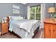 Tranquil bedroom featuring a soft bed, artwork, and a view of the trees at 10501 Dotham Ct, Tampa, FL 33626