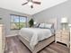 Bright main bedroom with wood-look floors, ceiling fan, and large window allowing ample natural light at 10501 Dotham Ct, Tampa, FL 33626