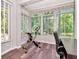 Sunroom with large windows offering lush backyard views; exercise equipment at 10501 Dotham Ct, Tampa, FL 33626