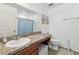 Bathroom with large mirror, granite countertop, and wood cabinetry at 10603 Massimo Dr, Wimauma, FL 33598