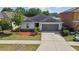 Single-story home features a two-car garage, landscaped front yard, and paved driveway at 10603 Massimo Dr, Wimauma, FL 33598