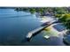 Aerial view showcasing a pier with access to open water, highlighting waterfront amenities and potential at 10609 Orange Grove Dr, Tampa, FL 33618