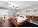 Bright bedroom features a ceiling fan, hardwood floors, and a wooden writing desk at 10609 Orange Grove Dr, Tampa, FL 33618