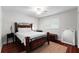 Bedroom features decorative black iron bed frame, dark wood floors, and natural lighting at 10609 Orange Grove Dr, Tampa, FL 33618