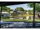 Scenic view of the community lake featuring a fishing dock and a covered picnic area on the grass at 10609 Orange Grove Dr, Tampa, FL 33618