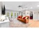 Bright living room featuring a comfortable leather sofa, large windows, neutral tones, and an inviting atmosphere at 10609 Orange Grove Dr, Tampa, FL 33618