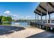 Lake view from a covered picnic pavilion on the beach with a sandy shoreline and docks at 10609 Orange Grove Dr, Tampa, FL 33618