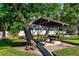 A small picnic shelter nestled under a large tree offering a shady retreat in the community park at 10609 Orange Grove Dr, Tampa, FL 33618