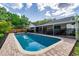 Backyard shows a gorgeous pool surrounded by a brick patio, fenced-in for safety at 10609 Orange Grove Dr, Tampa, FL 33618