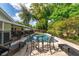 Backyard features a pool and a patio seating area shaded by mature trees at 10609 Orange Grove Dr, Tampa, FL 33618