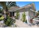 Inviting home exterior featuring a well-manicured landscape with tropical plants, flowers, and a cozy screened entryway at 11841 Whisper Creek Dr, Riverview, FL 33569