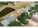 Aerial view of a home nestled among mature trees in a well-kept neighborhood near a pond at 13420 Copper Head Dr, Riverview, FL 33569