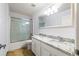 Bathroom features a double vanity with granite countertops, framed mirror, and a glass-enclosed shower at 13420 Copper Head Dr, Riverview, FL 33569