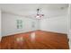 The spacious bedroom features hardwood floors, white walls, a ceiling fan, and two windows at 13420 Copper Head Dr, Riverview, FL 33569