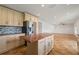 Bright kitchen features an island, stainless steel refrigerator, neutral cabinets, and tile backsplash at 13420 Copper Head Dr, Riverview, FL 33569