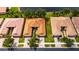 Aerial view of homes with clay tile roofs near a serene lake, showcasing the well-maintained neighborhood at 16261 Amethyst Key Dr, Wimauma, FL 33598