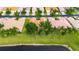 A serene lakefront home featuring a lush, green lawn and mature shade trees in a peaceful residential area at 16261 Amethyst Key Dr, Wimauma, FL 33598