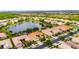 Picturesque aerial view of a neighborhood surrounding a central lake, highlighting the community's layout and green spaces at 16261 Amethyst Key Dr, Wimauma, FL 33598