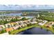 Panoramic aerial shot of a lakefront community with neatly arranged houses, mature trees, and tranquil water views at 16261 Amethyst Key Dr, Wimauma, FL 33598
