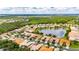 An aerial shot displays a neighborhood with a central lake and lush greenery, providing a scenic residential setting at 16261 Amethyst Key Dr, Wimauma, FL 33598