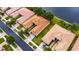 An aerial view of homes with tile roofs in a neighborhood near a lake at 16261 Amethyst Key Dr, Wimauma, FL 33598