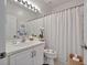 Neutral bathroom featuring a modern vanity, new lighting, a framed mirror, and a tiled shower with curtain at 16261 Amethyst Key Dr, Wimauma, FL 33598