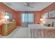 Inviting bedroom with dresser, lamps, ceiling fan, neutral walls, and patterned curtains at 16261 Amethyst Key Dr, Wimauma, FL 33598