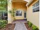 The front porch with brick ground cover, landscaping, and the front door and window at 16261 Amethyst Key Dr, Wimauma, FL 33598