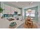 Bright kitchen boasts white cabinets, turquoise backsplash, breakfast nook, and modern fixtures at 16261 Amethyst Key Dr, Wimauma, FL 33598