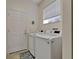 Laundry room featuring a side-by-side washer and dryer, window and tile floors at 16261 Amethyst Key Dr, Wimauma, FL 33598