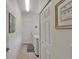 Hallway leading to the laundry room with white cabinets and white washer and dryer at 16261 Amethyst Key Dr, Wimauma, FL 33598