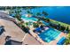 Aerial view of community pool with multiple swimming areas and landscaping near a lake at 16261 Amethyst Key Dr, Wimauma, FL 33598