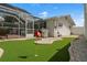 Backyard view featuring putting green and outdoor patio with grill at 1698 Eden Ct, Clearwater, FL 33756