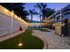 Backyard with artificial turf putting green, BBQ and an inviting screened-in lounge area at 1698 Eden Ct, Clearwater, FL 33756