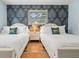 Bedroom featuring two beds with palm wallpaper and a window offering natural light at 1698 Eden Ct, Clearwater, FL 33756