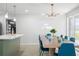 Bright dining room with contemporary lighting, stylish furniture and a view of the kitchen area at 1698 Eden Ct, Clearwater, FL 33756
