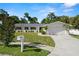 Single-story home with a two-car garage, tropical landscaping, well-maintained lawn, a mailbox, and a concrete driveway at 1698 Eden Ct, Clearwater, FL 33756