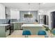 Modern kitchen with green and white cabinets, stainless steel appliances, and island with a white countertop at 1698 Eden Ct, Clearwater, FL 33756
