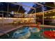 Screened-in pool area illuminated with decorative string lights, creating a magical nighttime ambiance at 1698 Eden Ct, Clearwater, FL 33756