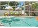 Inviting screened pool area with comfortable lounge chairs and umbrellas at 1698 Eden Ct, Clearwater, FL 33756