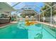 Inviting screened-in pool area featuring clear blue water, hot tub, and fun floats for relaxation and entertainment at 1698 Eden Ct, Clearwater, FL 33756