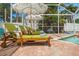 Comfortable lounge chairs by the pool, shaded by elegant umbrellas, in a screened enclosure at 1698 Eden Ct, Clearwater, FL 33756