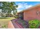 Brick home featuring a screened entryway, manicured landscaping, and a brick walkway, well maintained at 1702 Miller S Rd, Valrico, FL 33594
